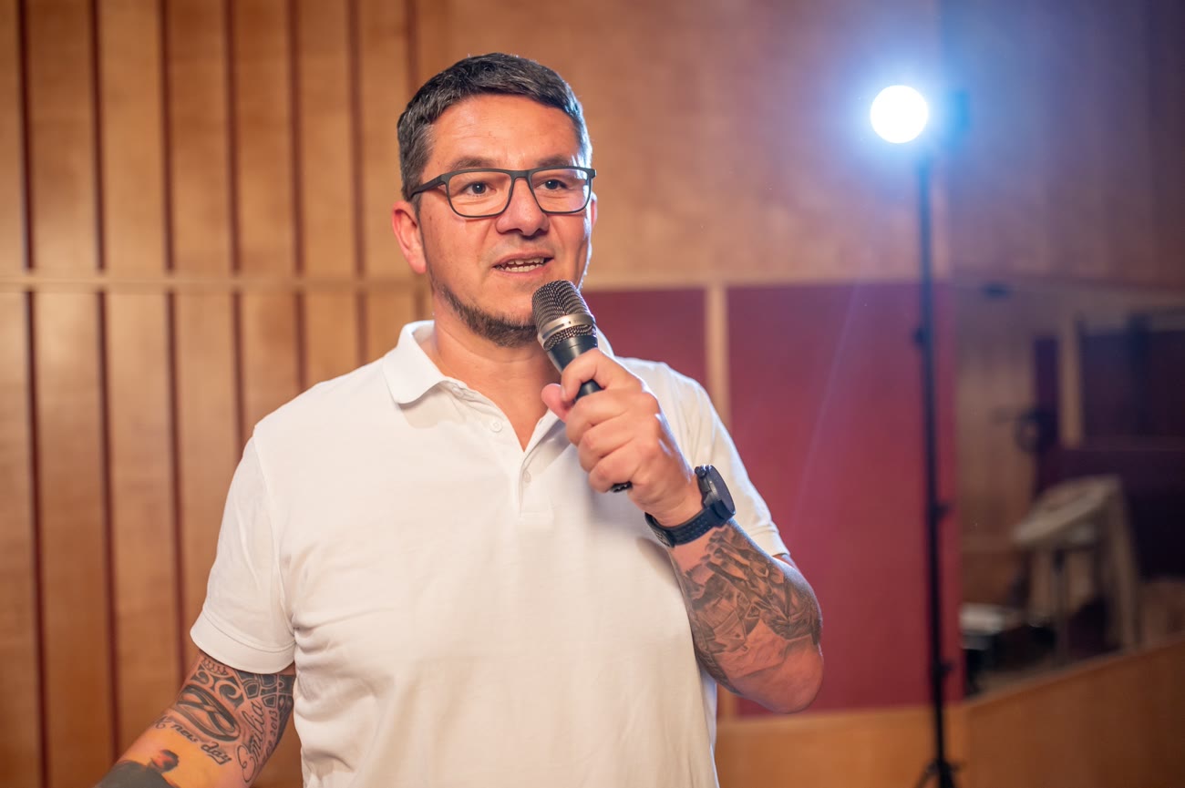Markus Warscher am Mikrofon im Spotlight auf der Bühne.